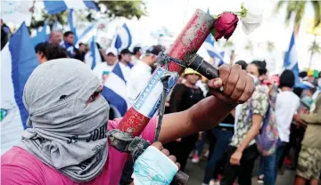  ??  ?? A protester poses with his homemade mortar during a protest against Ortega’s government in Managua, Nicaragua. — Reuters photo