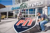  ??  ?? Dave Wright, left, and Chris Rivera of M&J Signs prepare to install the Pit sign next to new DreamStyle Arena signage on Oct. 26, 2017. The signs are now down over a money dispute.