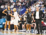  ?? Jessica Hill / Associated Press ?? UConn head coach Geno Auriemma, right, talks with Crystal Dangerfiel­d (5) as associate head coach Chris Dailey talks with Olivia Nelson-Ododa (20) in a Jan. 23 game against Tennessee.