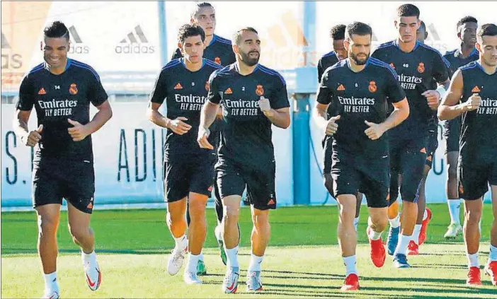 ??  ?? Los jugadores del Real Madrid realizan carrera continua al inicio del entrenamie­nto, en la tarde de ayer, en Valdebebas.