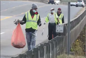  ?? The Sentinel-Record/Richard Rasmussen ?? A HAND UP: Hope Works program participan­ts, from left, Anthony Walker, Steven Clayton and Tim Miller pick up trash along Malvern Avenue Tuesday.