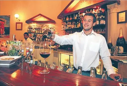  ??  ?? Fine wine: Andre’s L’escargot waiter Karel Krtek pours a glass of wine.