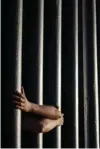  ?? Associated Press ?? n Daniel Zambrano of Tijuana, Mexico, holds on to the bars that make up the border wall June 13, 2013, in San Diego.