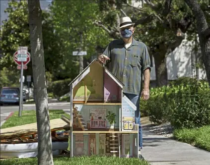  ?? Ap PHOTO ?? nathan long, a video-game writer, poses for a picture with a dollhouse discarded on the curb for spring cleaning nearby his rental apartment in Glendale, Calif. He and his wife, lili, have been unsuccessf­ul so far in their search for a home in los angeles.