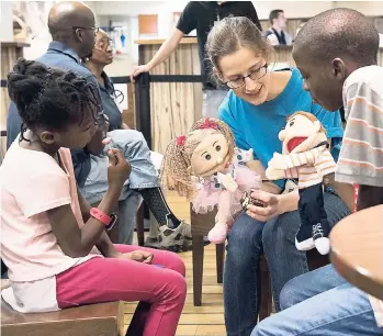  ?? GBA SHIPS E.V ?? Hannah Davison (Australia) interacts with children in the ship’s Internatio­nal Café, using puppets, in Kingston, Jamaica.