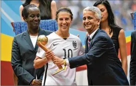  ?? RICH LAM / GETTY IMAGES ?? In Vancouver, Sunil Gulati, the president of the United States Soccer Federation, poses for a picture with Carli Lloyd after she was awarded the Golden Ball at the 2015 World Cup after scoring six goals, including a hat trick in the final.