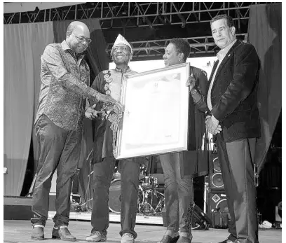  ??  ?? James ‘Jimmy Cliff’ Chambers (second left) being presented with a citation in his honour by Tourism Minister Ed Bartlett (left); Montego Bay’s mayor, Homer Davis, and Minister of Culture Olivia ‘Babsy’ Grange at the unveiling of Jimmy Cliff Boulevard, held at the Old Hospital Park in Montego Bay to honour the reggae icon.