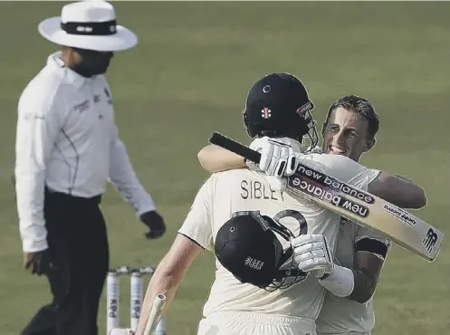  ??  ?? 0 England captain Joe Root celebrates with Dom Sibley after scoring a hundred during day one of the first Test against India in Chennai