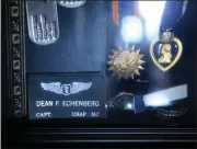  ?? ?? Vietnam veteran Dean Echenberg's name patch and Purple Heart are displayed in a case at his home.