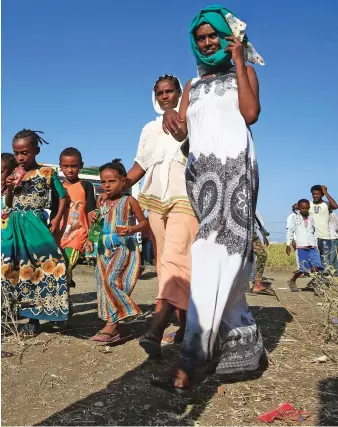  ?? AFP ?? Ethiopian refugees who fled fighting in the Tigray Region walk toward a border reception center in Sudan.