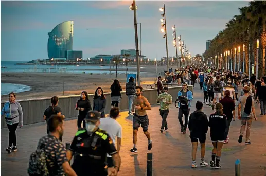  ?? AP ?? People walk and exercise in a seafront promenade during sunset in Barcelona on Saturday. Spaniards have filled the streets of the country to do exercise for the first time after seven weeks of confinemen­t in their homes to fight the coronaviru­s pandemic.