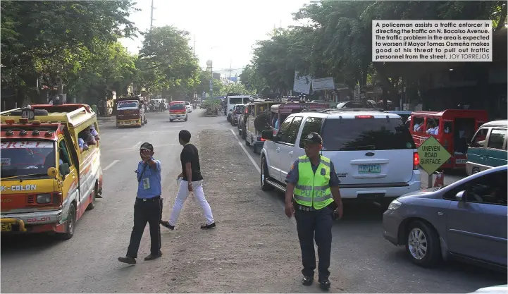  ?? JOY TORREJOS ?? A policeman assists a traffic enforcer in directing the traffic on N. Bacalso Avenue. The traffic problem in the area is expected to worsen if Mayor Tomas Osmeña makes good of his threat to pull out traffic personnel from the street.