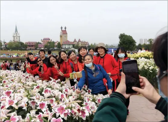  ?? LIU BIN / FOR CHINA DAILY ?? Senior citizens check out floral displays at a Flower Exhibition in Wuhan, Hubei province, on Oct 24.