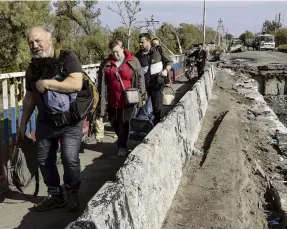  ?? PHOTO: GETTY IMAGES ?? Kupiansk refugees flee over a destroyed bridge in Kupiansk, Ukraine, yesterday. The city has been captured by Ukrainian armed forces pushing back the Russians.
