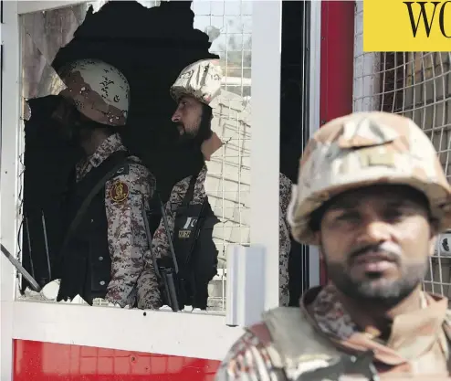  ?? SHAKIL ADI/THE ASSOCIATED PRESS ?? Pakistani troops patrol the compound of the Chinese consulate in Karachi, Pakistan, on Friday, after gunmen stormed the building, triggering an intense shootout that saw two police, two civilians and three attackers die.