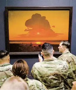  ?? GREGG VIGLIOTTI NYT ?? Members of the 353rd Civil Affairs Command examine “Red Sunset,” a landscape painting by Arkhyp Kuindzhi, whom the Metropolit­an Museum of Art recently reclassifi­ed as a Ukrainian artist rather than a Russian one.