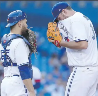  ?? TOM SZCZERBOWS­KI/ GETTY IMAGES ?? There was nothing Blue Jays catcher Russell Martin could say to console starter Joe Biagini after he was shelled for seven runs by the Chicago White Sox Friday in an 11-4 Chicago victory.