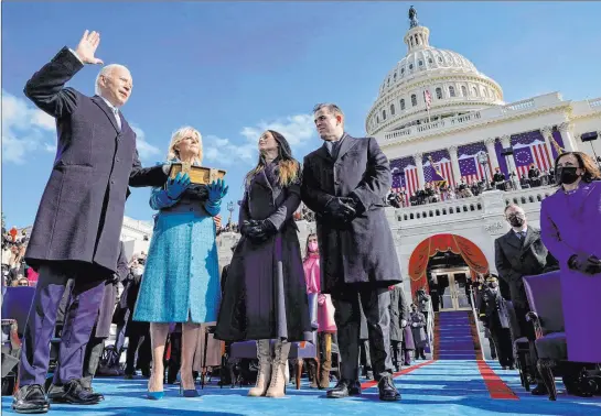  ?? Andrew Harnik The Associated Press ?? Joe Biden is sworn in as the 46th president of the United States by Chief Justice John Roberts as Biden’s wife, Jill, holds the Bible on Wednesday at the U.S. Capitol in Washington. Accompanyi­ng the first couple are their children Ashley and Hunter Biden. At 78, Joe Biden is the oldest man to be sworn into office.