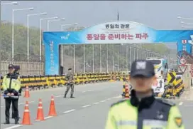  ?? AP ?? South Korean police officers and soldier stand at Unificatio­n Bridge, which leads to the truce village of Panmunjom in Paju, South Korea, on Wednesday.