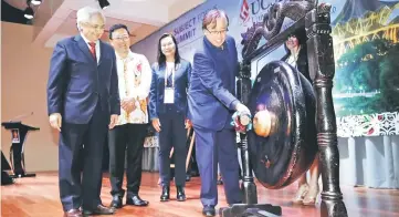  ??  ?? Abang Johari strikes the gong to launch the summit last night. Also seen is (from left) Khalid, UCSI university council chairman and founder Dato Peter Ng and QS Asia chief executive officer Mandy Mok. — Photo by Chimon Upon