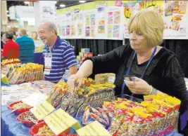  ?? Michael Quine Las Vegas Review-journal @Vegas88s ?? Pat Bana, right, restocks products at the Raisels-chortles booth Tuesday during the annual conference of the School Nutrition Associatio­n at Mandalay Bay Convention Center.