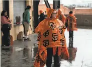  ??  ?? Giants fans came prepared for rainy weather, with some donning colorful ponchos at Oracle Park.