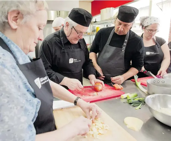  ?? PHOTOS: PIERRE OBENDRAUF/ THE GAZETTE ?? Chef Daniel Vézina, second from right, gives tips to Gerry Doutre, second from left, president and CEO of Ultima Foods. The two are promoting the growth of collective kitchens in Quebec.