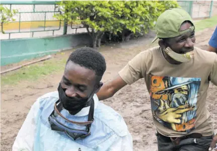  ?? ?? Jockey Shavon Townsend (left) and trainer Fitzgerald Richards bask in their accomplish­ment of winning the first race on Monday, July 12, 2021 at Caymanas Park with Sacrifice.