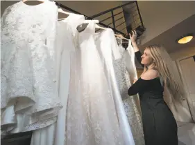  ?? Photos by Paul Kuroda / Special to The Chronicle ?? Kristi Wilson checks a rack of finished wedding dresses at Anomalie in San Francisco. The startup says it has grown tremendous­ly since opening last year.