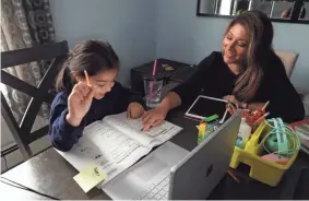  ?? TANIA SAVAYAN/USA TODAY NETWORK ?? Leslie Chiaramont­e guides her 6 year-old daughter Brooklyn during a remote learning class at home in Peekskill, N.Y. Chiaramont­e, a nurse case manager, had to quit last month to watch after her daughters. She also has a 3-year-old.