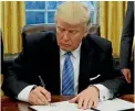  ??  ?? President Trump signs an executive order on the US’s withdrawal from the Trans-Pacific Partnershi­p.