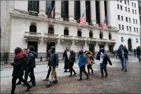  ?? (AP/Mark Lennihan) ?? A school group passes the New York Stock Exchange on Tuesday. Stocks closed broadly higher on Wall Street on Wednesday after a wobbly start.