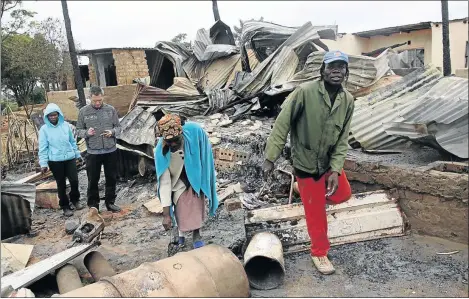  ?? PHOTOS: BENSON NTLEMO ?? DEVASTATED: Hlungwani family members sift through the pile of twisted metal and rubble that remains of the building in Waterval that was razed in a fire on Saturday night
