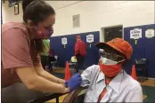  ?? BEN FINLEY — THE ASSOCIATED PRESS ?? Debbie Monahan, a school nurse, pulls down Charles Robbins’ sleeve after giving him his second shot of the coronaviru­s vaccine at Surry County High School in Dendron, Va., on Saturday.