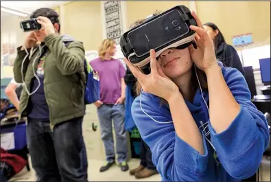  ?? Arkansas Democrat- Gazette/ BENJAMIN KRAIN ?? Kacie Skelton ( right) and other Little Rock Central High School students try out virtual- reality headsets during a demonstrat­ion Thursday at the school.