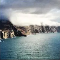  ??  ?? The imposing cliffs of the Blasket Islands are blanketed in early morning cloud.