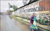  ?? REUTERS ?? A woman walks past a graffiti reading ‘No political parties, Yes to selfdeterm­ination’ in the Purepecha town.