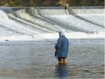  ?? GEORGE THOMPSON/CHICAGO TRIBUNE ?? A bundled-up a fisherman tries his hand at catching a few at the Carpenter dam in the Fox River in Carpenters­ville in November 2005. Officials say the dam will be removed in spring or summer.