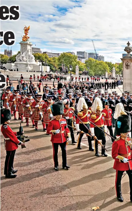  ?? ?? Nod to her London home: The state gun carriage carrying the coffin of the late monarch goes past the Queen Victoria Memorial and Buckingham Palace, where staff are standing outside to pay their respects