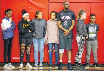  ??  ?? Const. Chabine Tucker waits with the kids to be sorted out on teams. From left are Mirane, Aisha, Makayla, TriAnne, Const. Tucker, Kailea, and Amanuel.