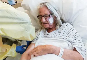  ?? Heidi de Marco / KHN ?? Janet Prochazka, 75, winces as she gets a shot during her stay at Zuckerberg San Francisco General Hospital. After being treated for weeks there and at a rehabilita­tion facility, she emerged weak and unable to think clearly.