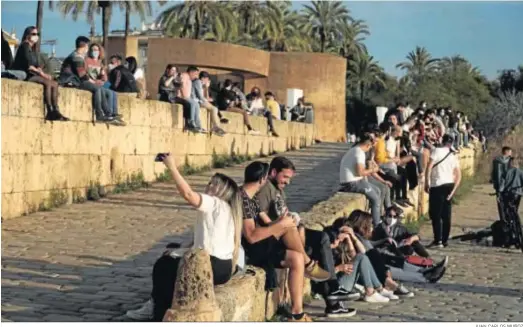  ?? JUAN CARLOS MUÑOZ ?? Grupos de jóvenes en el paseo junto al río Guadalquiv­ir en Sevilla.