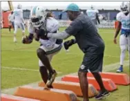  ?? CHARLES TRAINOR — THE ASSOCIATED PRESS ?? Miami Dolphins running back Jay Ajayi runs a drill Monday. Dolphins coach Adam Gase said Ajayi is being evaluated for a possible concussion.
