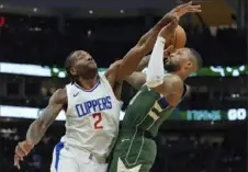  ?? Morry Gash/Associated Press ?? The Bucks’ Damian Lillard shoots against the Clippers’ Kawhi Leonard during the first half Monday in Milwaukee.