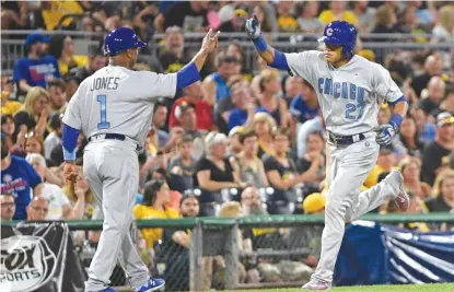  ??  ?? Shortstop Addison Russell celebrates with third- base coach Gary Jones after his homer in the seventh inning. | JUSTIN BERL/ GETTY IMAGES