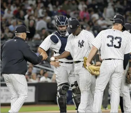  ?? BILL KOSTROUN - THE ASSOCIATED PRESS ?? New York Yankees manager Joe Girardi, left, takes the ball fromNew York Yankees starting pitcher Luis Severino as he leaves the game during the seventh inning of a baseball game Monday, at Yankee Stadium in New York.