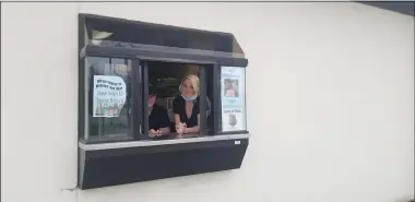  ?? JORDANA JOY — THE MORNING JOURNAL ?? Martino’s Internatio­nal Cafe staff peak out the restaurant’s drive-thru window at 4415 Liberty Ave. in Vermilion. The restaurant has had its dining rooms open for the past few months and is still seeing a steady flow of carry-out orders.