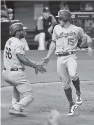  ?? THE ASSOCIATED PRESS ?? The Los Angeles Dodgers’ Yasiel Puig (66) and Austin Barnes (15) congratula­te each other after they and Chris Taylor scored on a double by Justin Turner during the third inning Thursday against the Miami Marlins.