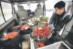  ??  ?? A delivery staff of a florist places a bouquet made of strawberri­es and flowers, priced at 450RMB, on Valentine’s Day in Beijing. China consumer inflation also rose more than expected, nearing a three-year high as fuel and food prices jumped, data...