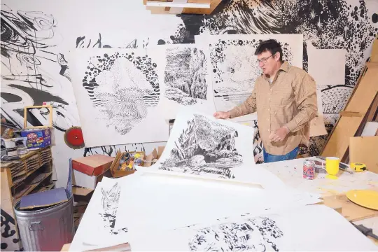  ?? ADOLPH PIERRE-LOUIS/JOURNAL ?? Artist Larry Bob Phillips unfurls drawings in his South Valley studio.